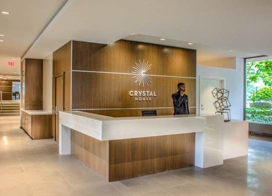 A reception area with a person standing behind the desk.