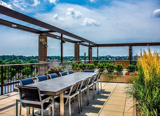 A rooftop with a long table and chairs
