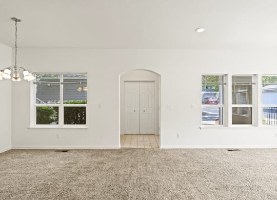 a living room with white walls and a carpeted floor