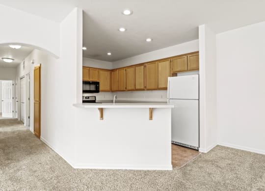 a kitchen with white walls and brown cabinets