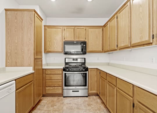 a kitchen with white countertops and wooden cabinets