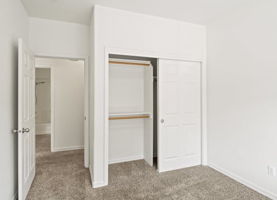 a bedroom with white walls and a carpeted floor