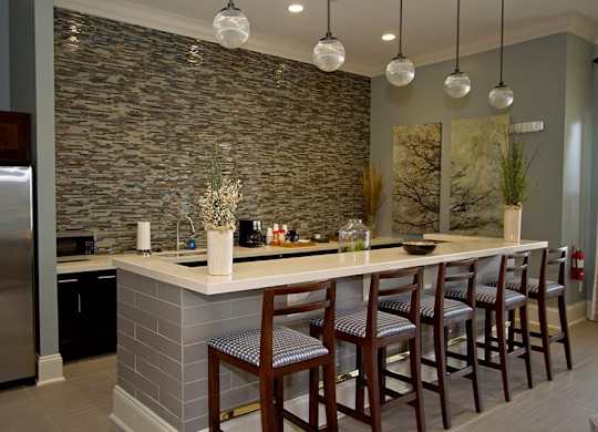 A kitchen with a bar area and chairs.
