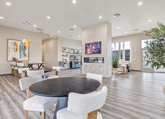 A modern dining room with a large table and chairs.