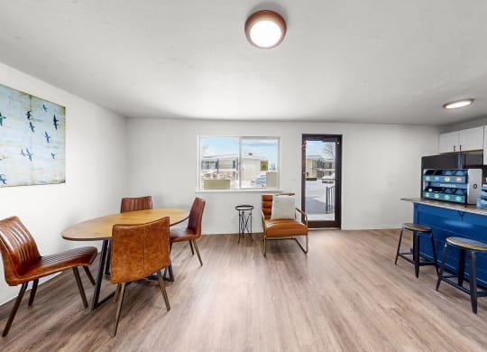 a dining room with a table and chairs and a kitchen with a blue counter