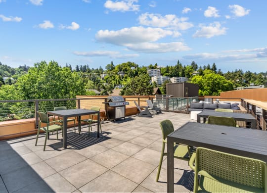 a rooftop patio with tables and chairs and a grill