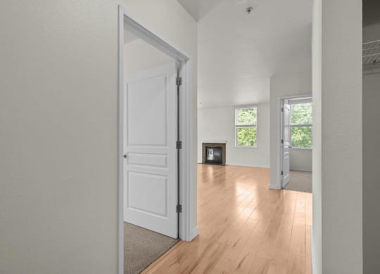 Hallway view into living room with white walls and wood-style flooring at Collins Circle apartments in the Goose Hollow district in Portland, Oregon.