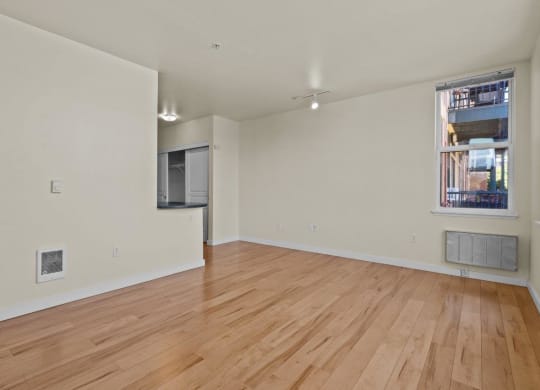Living room with wood-style flooring, white walls, and overhead light at Collins Circle apartments in the Goose Hollow district in Portland, Oregon.