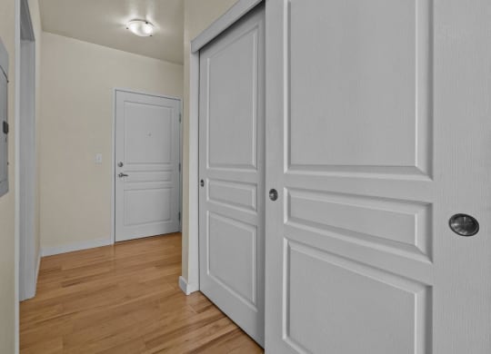 Bedroom with double closet and wood-style flooring at Collins Circle apartments in the Goose Hollow district in Portland, Oregon.