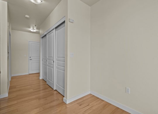 Bedroom with double closet and wood-style flooring at Collins Circle apartments in the Goose Hollow district in Portland, Oregon.