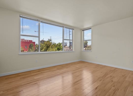 Large living room with windows showing nature view at Collins Circle apartments in the Goose Hollow district in Portland, Oregon.