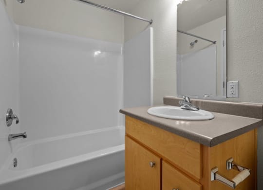 Bathroom with full tub/shower combo and white walls at Collins Circle apartments in the Goose Hollow district in Portland, Oregon.