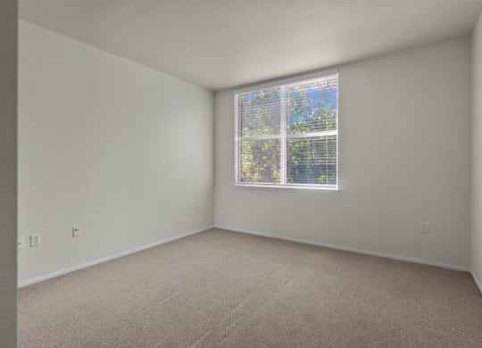Bedroom with large windows and white walls at Collins Circle apartments in the Goose Hollow district in Portland, Oregon.