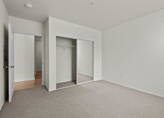 Bedroom with white walls and large double closet at Collins Circle apartments in the Goose Hollow district in Portland, Oregon.