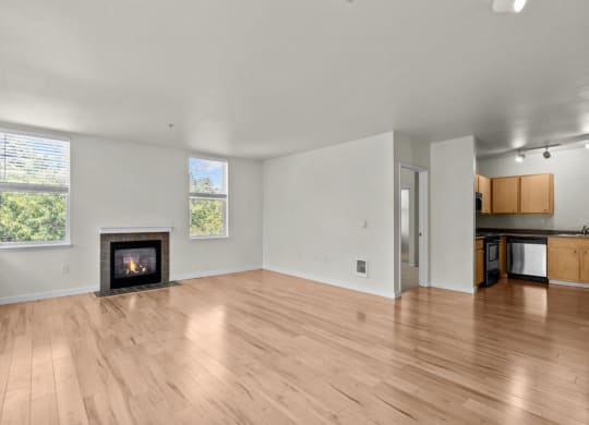 Living room with windows, fireplace, and wood-style flooring at Collins Circle apartments in the Goose Hollow district in Portland, Oregon.