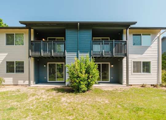 A two-story house with a balcony on the second floor.