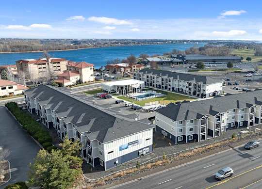 A large building complex is situated next to a busy highway.