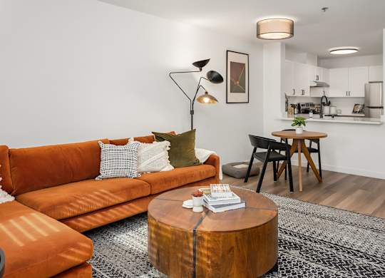 A living room with an orange couch and a coffee table.