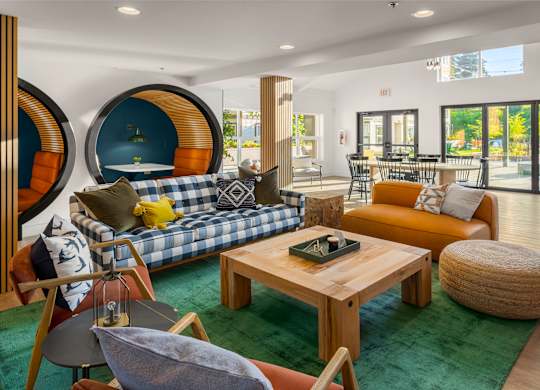 A modern living room with a blue and white sofa, a wooden coffee table, and a green rug.