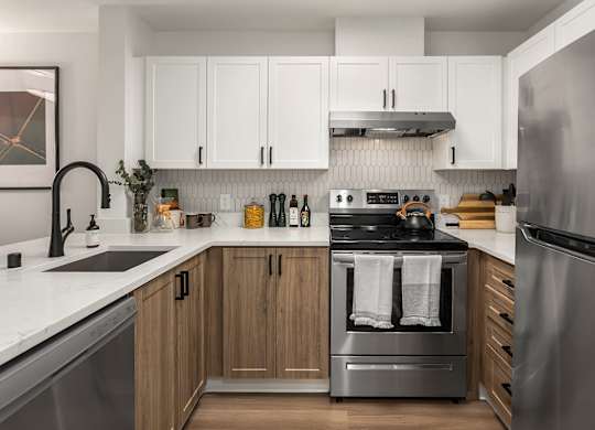 A modern kitchen with wooden cabinets and stainless steel appliances.