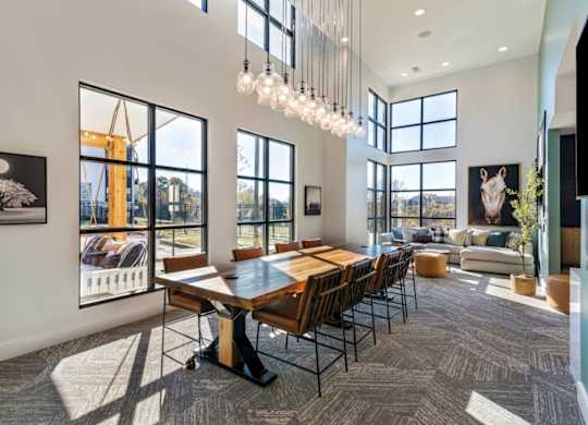 A modern dining room with a large table and chairs.