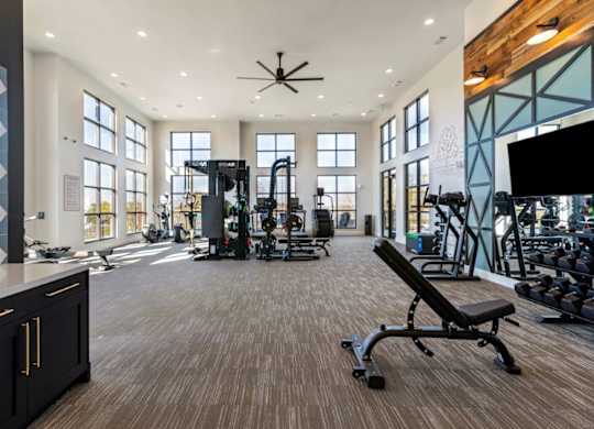 A gym with a variety of equipment including a bench press.