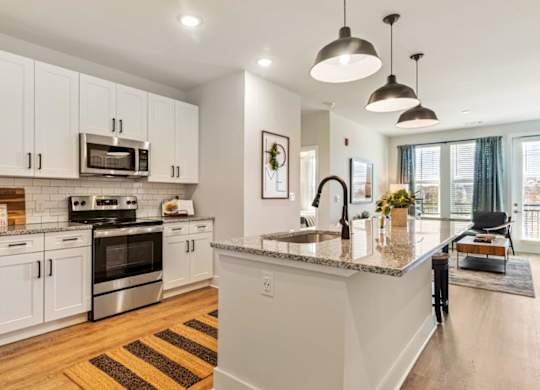 A kitchen with white cabinets and a granite countertop.