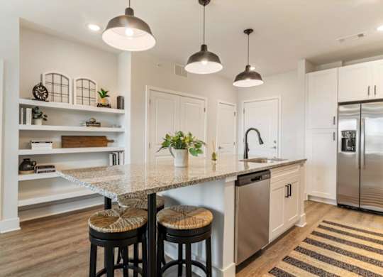 A kitchen with a granite countertop and stainless steel appliances.