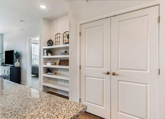 A white kitchen with a granite counter top and a white cabinet.