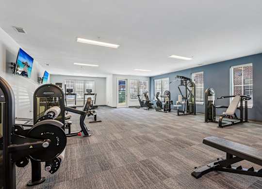 A gym with a variety of equipment including weights and machines.