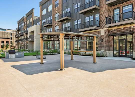 A large open courtyard with a wooden pergola in the middle.