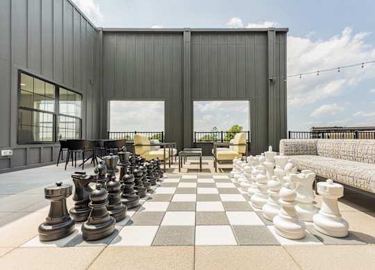 A giant chess set is set up on a checkered floor.