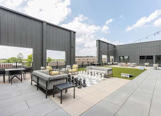 A modern outdoor seating area with a chess board and chairs.