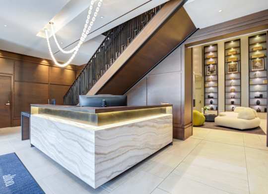 A reception area with a wooden counter and a staircase.