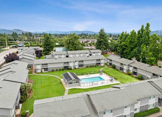Apartment complex with a pool and green lawns.