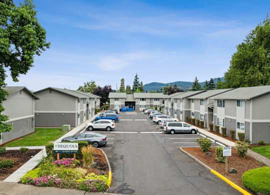 A Sequoia apartment complex with a parking lot in front.