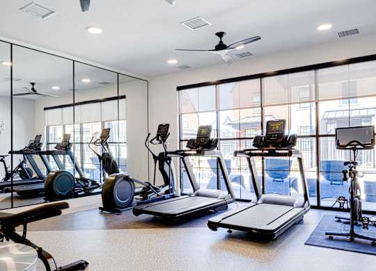 A gym with treadmills, exercise bikes, and elliptical machines.