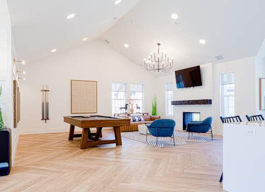 A living room with a pool table and a fireplace.