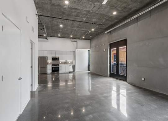 A large, empty room with a concrete floor and walls.
