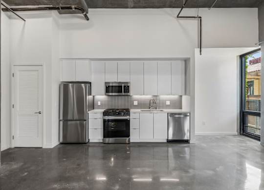 A modern kitchen with stainless steel appliances and white cabinets.