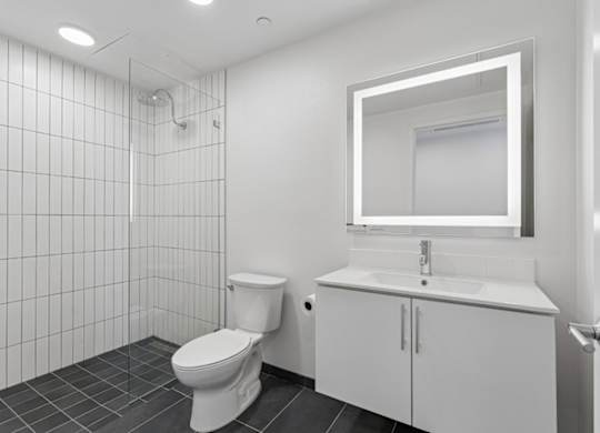 A white bathroom with a toilet, sink, and mirror.