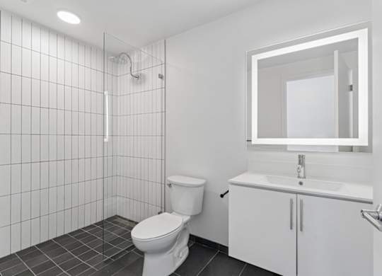 A white bathroom with a toilet, sink, and mirror.