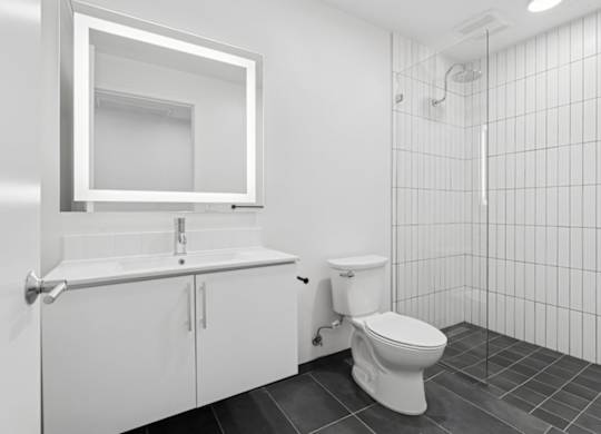 A white bathroom with a toilet, sink, and mirror.