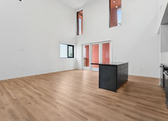 A room with wooden flooring and a black cabinet.