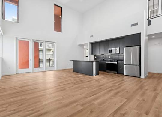 A kitchen with a refrigerator, oven, and sink.