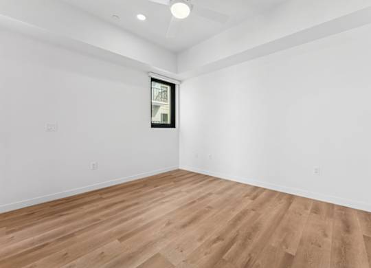 A room with wooden flooring and a window.