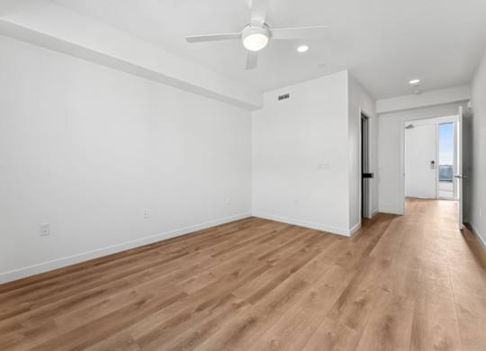 A room with wooden flooring and a ceiling fan.