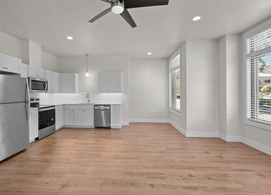 an empty kitchen with white cabinets and stainless steel appliances