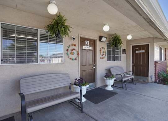 A bench is on the porch of a house.