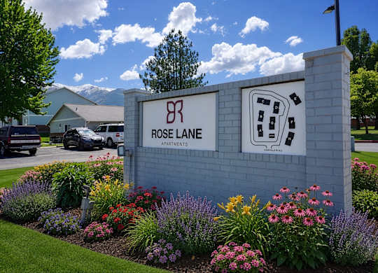 Rose Lane Apartments sign with a landscaped garden in front.